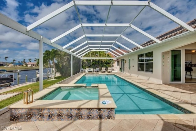 view of swimming pool with an in ground hot tub, a water view, a patio area, and a lanai