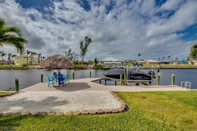 dock area with a lawn and a water view