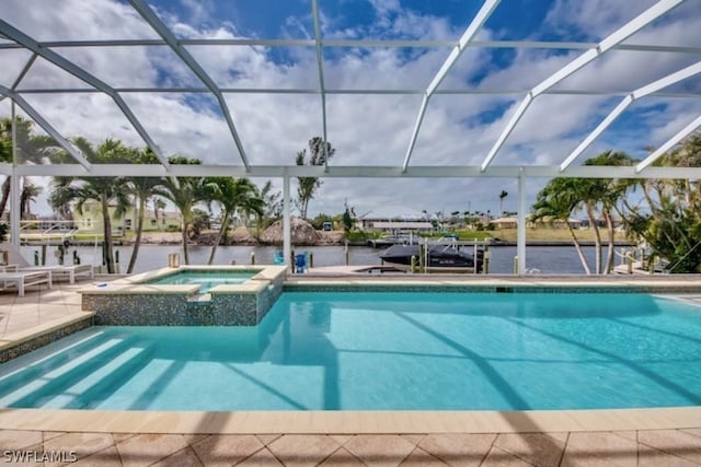 view of swimming pool with an in ground hot tub, a water view, glass enclosure, and a patio area