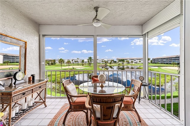 sunroom featuring a water view, ceiling fan, and a healthy amount of sunlight