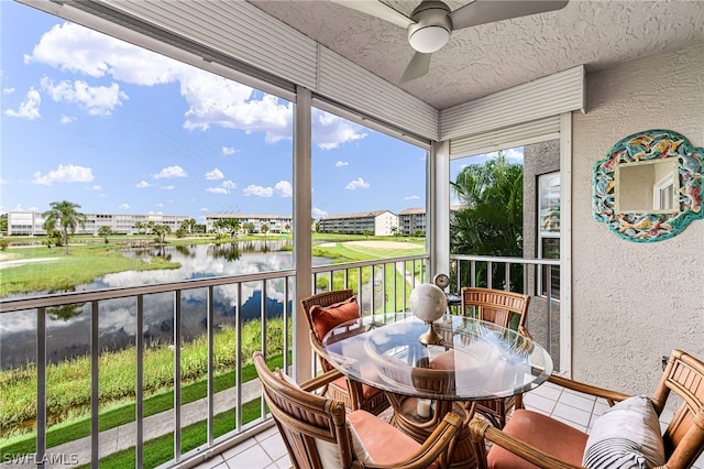 sunroom / solarium featuring ceiling fan and a water view