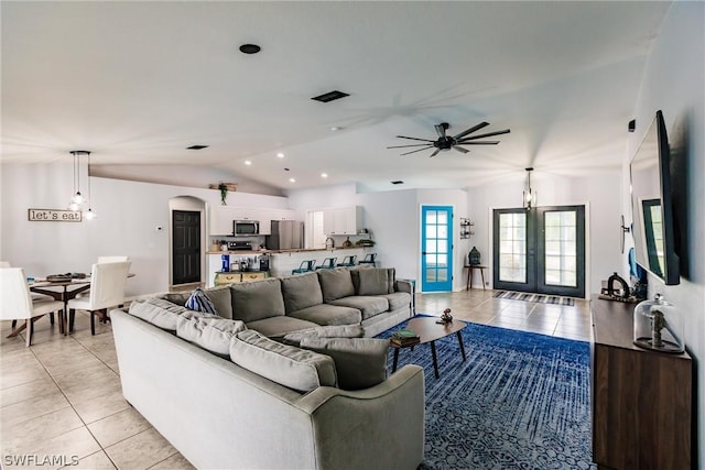 living room featuring ceiling fan, french doors, light tile patterned floors, and lofted ceiling