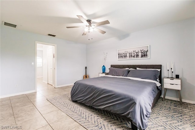 tiled bedroom with ceiling fan and ensuite bath