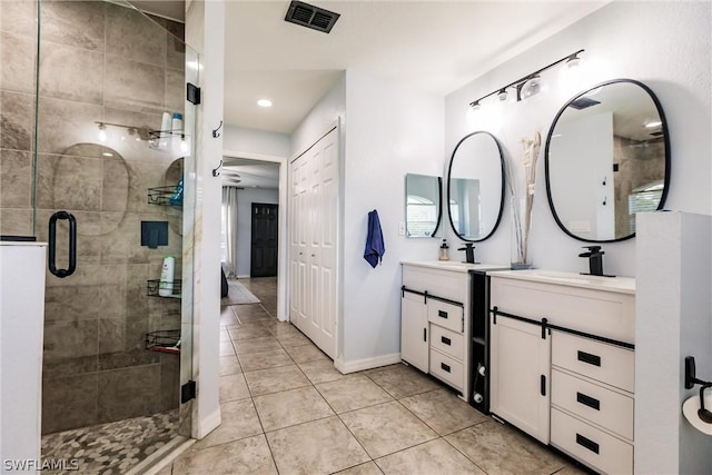 bathroom with tile patterned flooring, vanity, and a shower with shower door