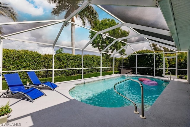 view of swimming pool with glass enclosure and a patio area