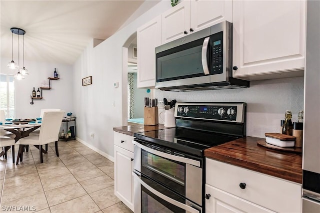 kitchen featuring appliances with stainless steel finishes, pendant lighting, white cabinets, butcher block counters, and light tile patterned flooring