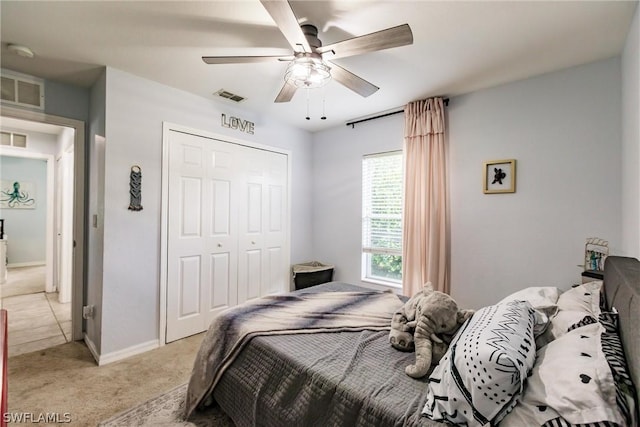 bedroom with ceiling fan, a closet, and light colored carpet