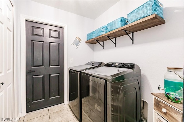 laundry area with washer and dryer and light tile patterned flooring