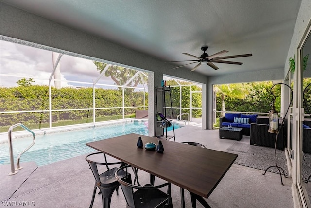 view of patio with outdoor lounge area, ceiling fan, and glass enclosure