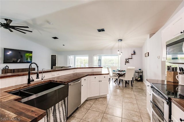 kitchen featuring butcher block countertops, white cabinetry, and appliances with stainless steel finishes