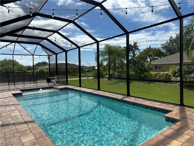 view of pool with a patio, pool water feature, a lanai, and a lawn