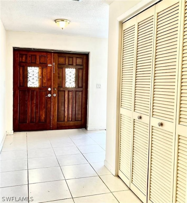 foyer featuring light tile patterned floors and a textured ceiling