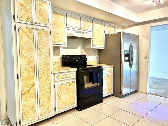 kitchen featuring stainless steel fridge, light tile patterned floors, and black range with electric cooktop