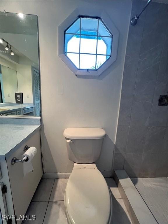 bathroom with tile patterned floors, a tile shower, and toilet