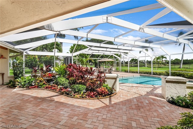 view of swimming pool with a patio area and a lanai