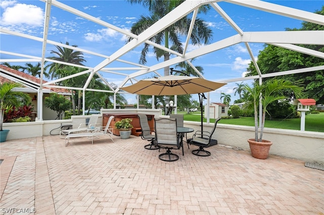 view of patio / terrace with a hot tub and a lanai