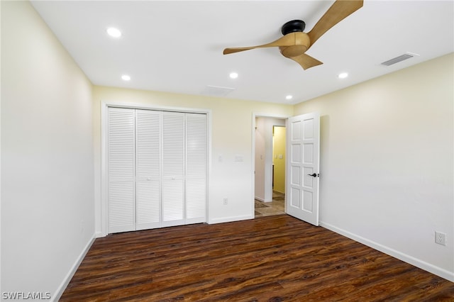 unfurnished bedroom featuring ceiling fan, dark wood-type flooring, and a closet