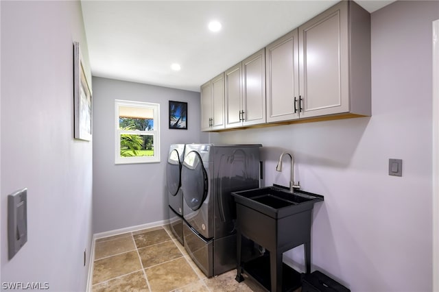 washroom with cabinets, separate washer and dryer, and sink