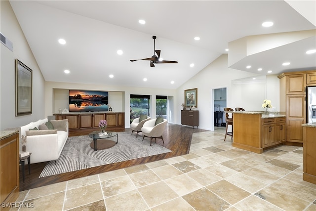 living room with ceiling fan, light hardwood / wood-style flooring, and high vaulted ceiling