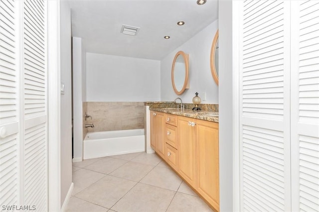 bathroom featuring tile patterned floors, vanity, and a tub