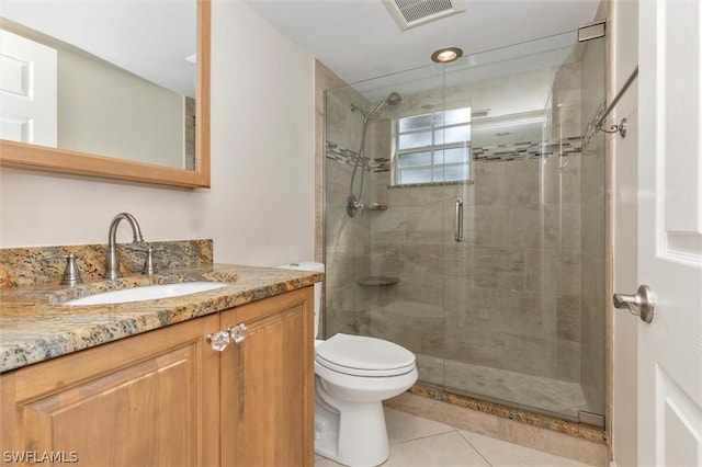 bathroom featuring tile patterned floors, vanity, an enclosed shower, and toilet