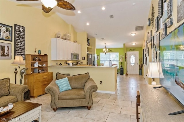 living room with light tile patterned floors and ceiling fan with notable chandelier