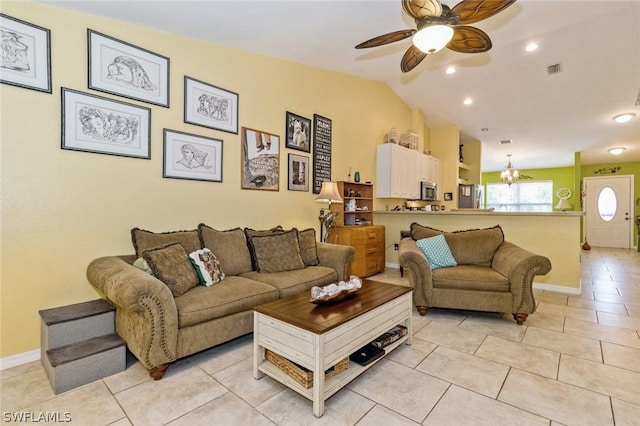 living room with vaulted ceiling, light tile patterned floors, and ceiling fan with notable chandelier