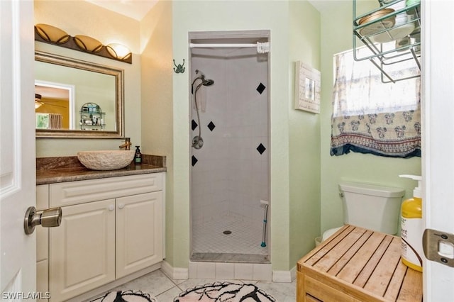 bathroom with tile patterned floors, toilet, vanity, and tiled shower