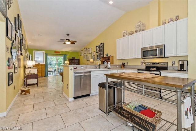 kitchen featuring ceiling fan, sink, stainless steel appliances, kitchen peninsula, and white cabinets