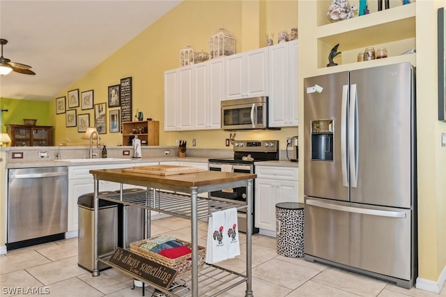 kitchen featuring appliances with stainless steel finishes, white cabinetry, ceiling fan, and lofted ceiling