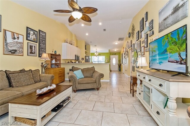 living room featuring light tile patterned floors, ceiling fan with notable chandelier, and vaulted ceiling