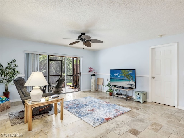 living room featuring ceiling fan and a textured ceiling