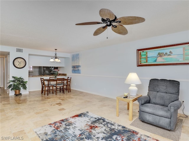 sitting room with ceiling fan with notable chandelier