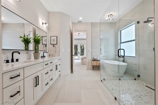 bathroom featuring tile patterned floors, plenty of natural light, plus walk in shower, and vanity