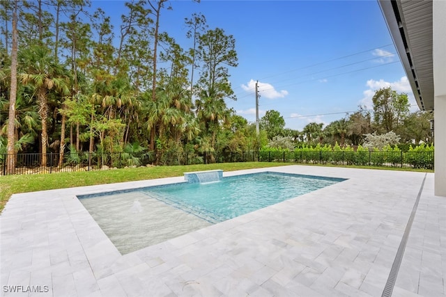 view of pool with pool water feature, a patio, and a lawn