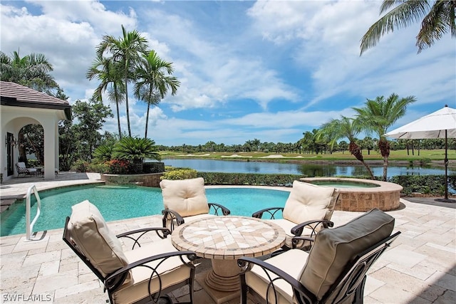 view of swimming pool featuring an in ground hot tub, a water view, and a patio area