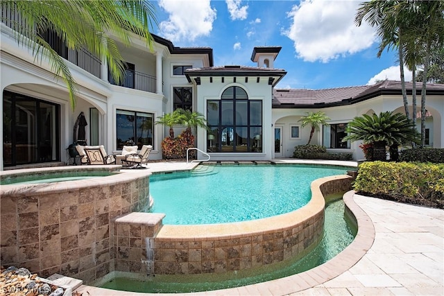 view of swimming pool with an outdoor hot tub