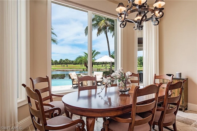 dining area featuring a water view and an inviting chandelier