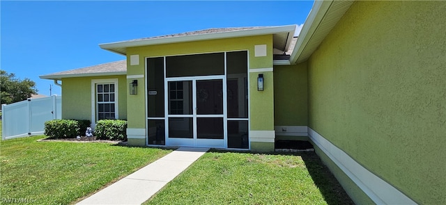 entrance to property with a lawn