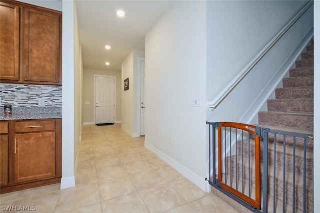 hallway featuring stairway, recessed lighting, light tile patterned flooring, and baseboards