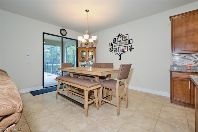 tiled dining area featuring a chandelier