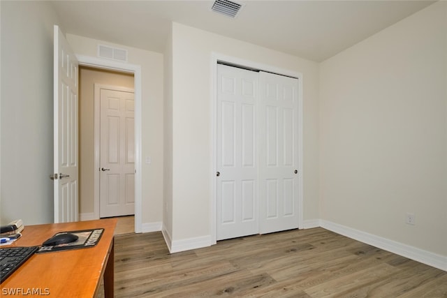 bedroom featuring light wood-type flooring and a closet