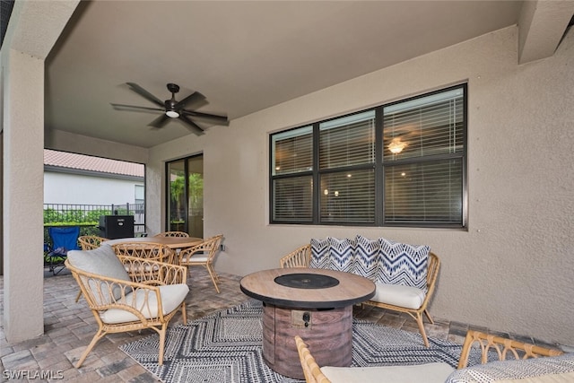 view of patio with ceiling fan and an outdoor fire pit