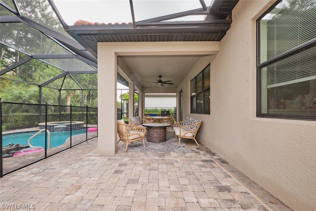 view of patio / terrace featuring a lanai, ceiling fan, and a pool with hot tub