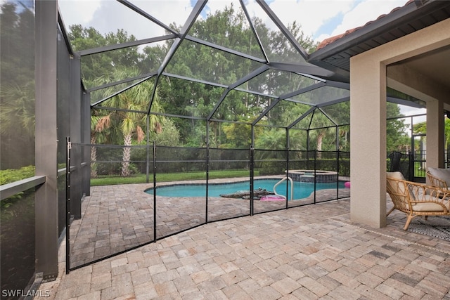 view of swimming pool with an in ground hot tub, glass enclosure, and a patio area