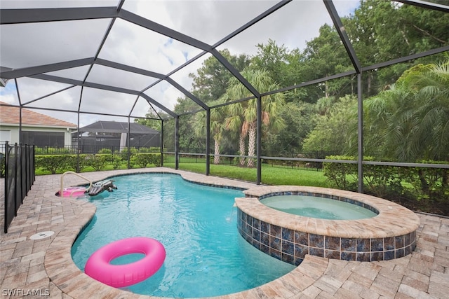 view of pool featuring an in ground hot tub, glass enclosure, and a patio area