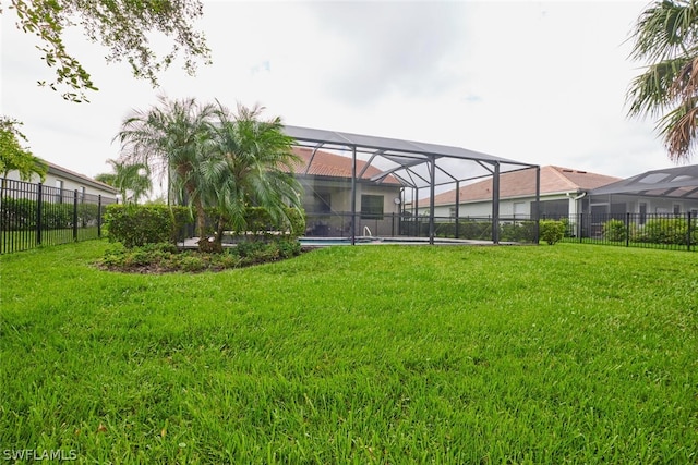 view of yard with a fenced in pool, a lanai, and fence