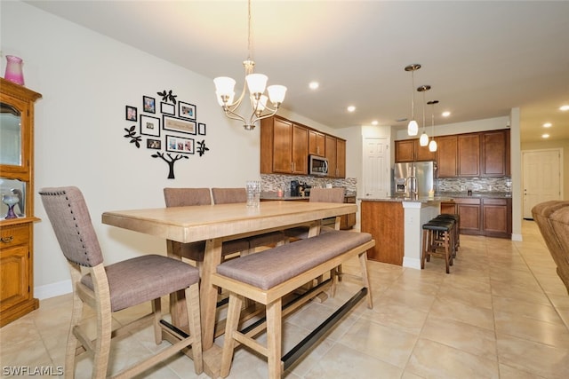 dining space with light tile patterned floors, a notable chandelier, and sink