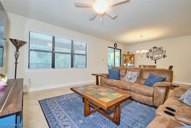 living room with ceiling fan with notable chandelier, light tile patterned flooring, and a wealth of natural light