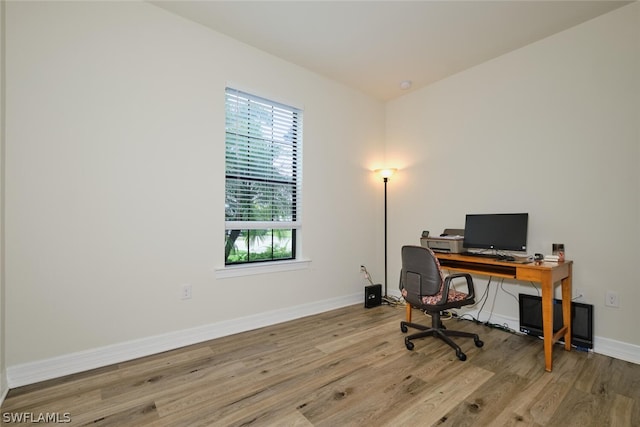 home office with light hardwood / wood-style floors